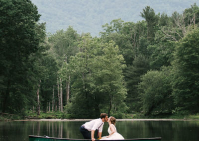 bride and groom kissing on canoe