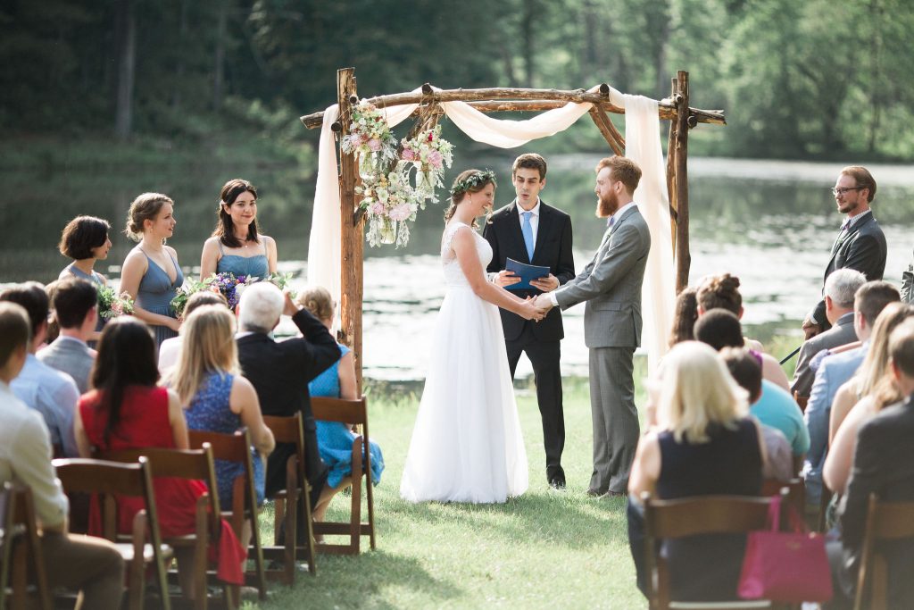 couple getting married in front of lake
