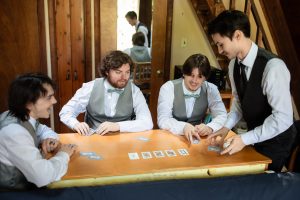 Groomsman playing cards in cottage before wedding